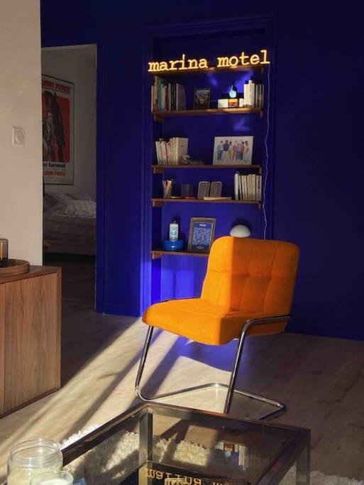 马赛Marina Motel的蓝色墙壁的房间的橙色椅子