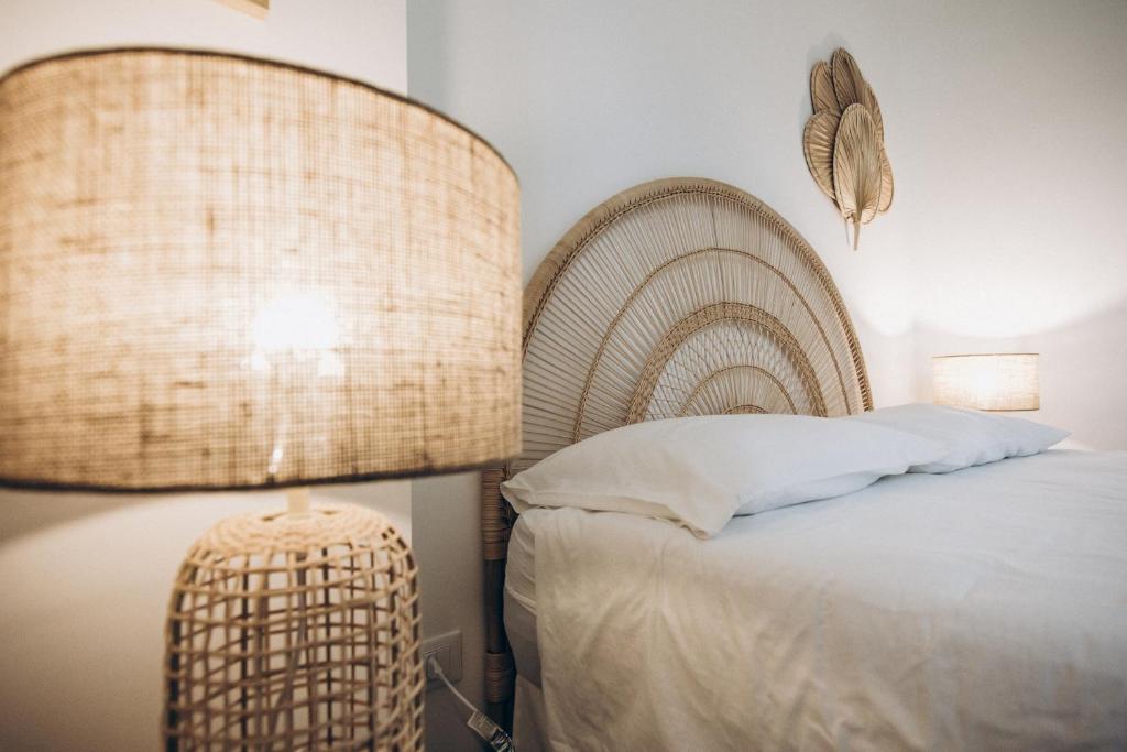 普尔萨诺Dalila Apulian Rental Rooms的一间卧室配有一张带大床头板和灯的床