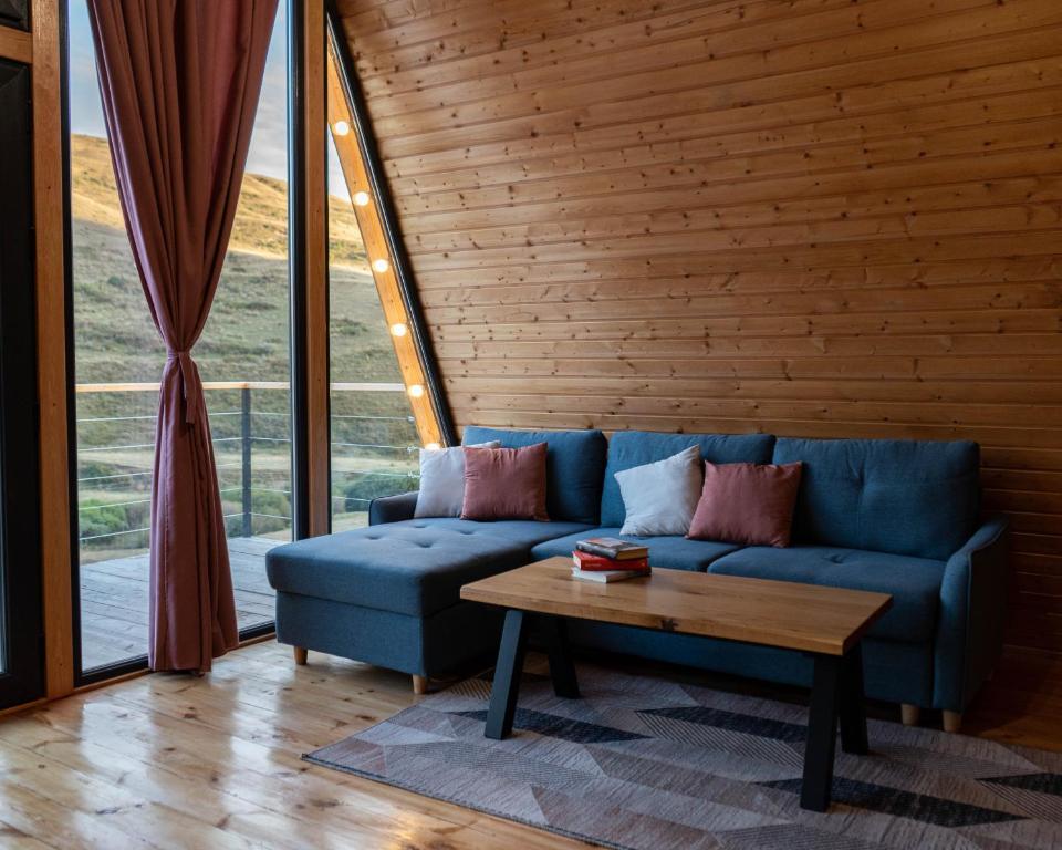 DrakhtikFocus Point Drakhtik - Rose Cabin的客厅配有蓝色的沙发和茶几