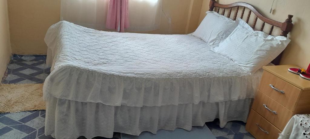 纳纽基Lk home的一间卧室配有一张带木制床头板的床