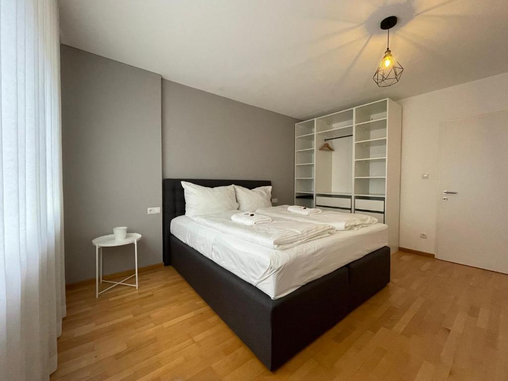 布雷根茨Stylische Wohnung mitten in der Stadt Bregenz的一间卧室配有一张大床和一张桌子