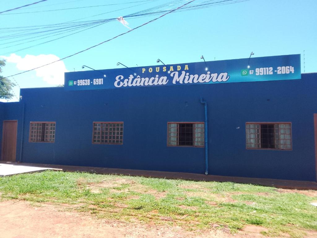 大坎普Pousada Estância Mineira的蓝色的建筑,旁边标有标志
