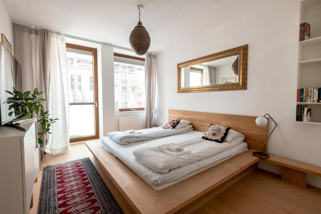 赫尔辛基2ndhomes Gorgeous and Modern 2BR Apartment with Balcony的卧室配有一张壁挂镜子的床