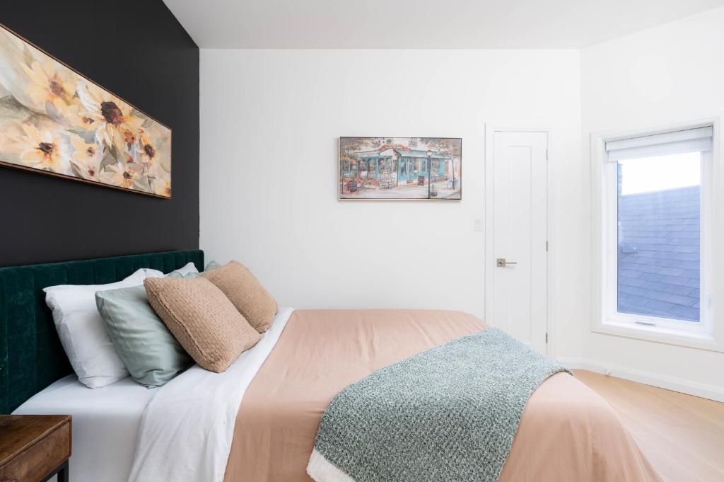 多伦多Luxury 2BD Oasis Steps to Little Italy!的卧室配有带枕头的床铺和窗户。