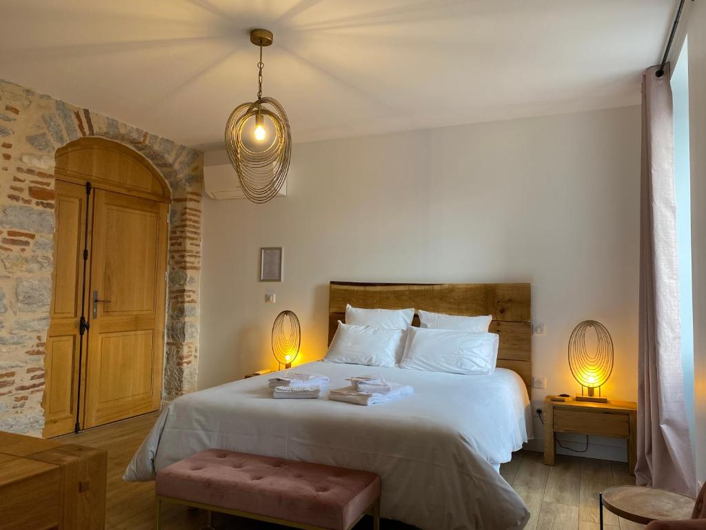 卡奥尔La Bellours Chambre D'Hôtes的一间卧室配有一张大床和两盏灯