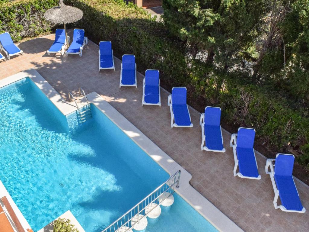 波连萨港Villa Alexia - APARTMENT CORAL - Puerto Pollensa的游泳池旁的一张蓝色躺椅