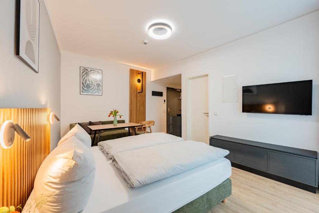 柏林Nena Apartments Berlin - Adlershof - "New Opening 2024"的一间卧室配有一张床,墙上配有电视