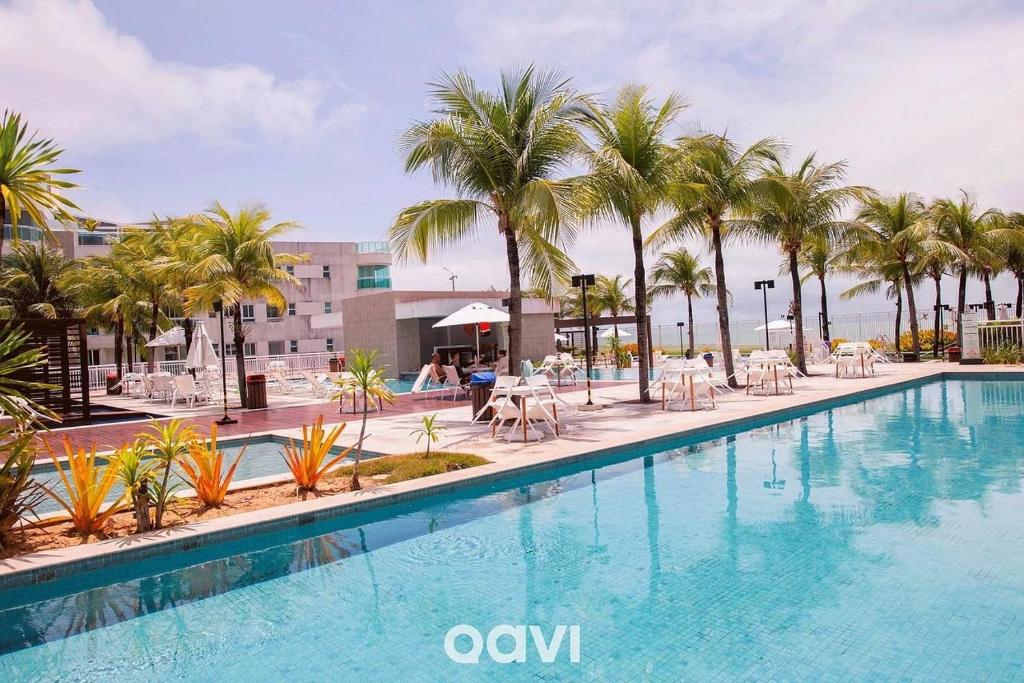 帕纳米林Qavi - Flat Resort Beira Mar Cotovelo #InMare133的一座棕榈树和椅子的大型游泳池