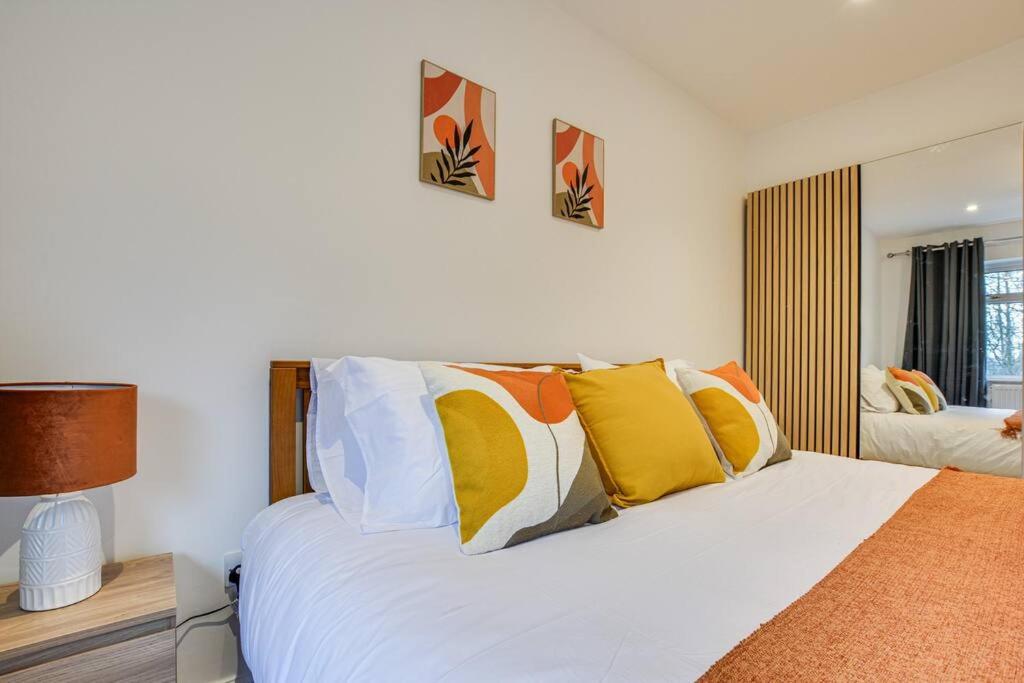 沃尔斯雷Calming and Serene 2 BR Getaway的卧室配有一张带彩色枕头的大型白色床。