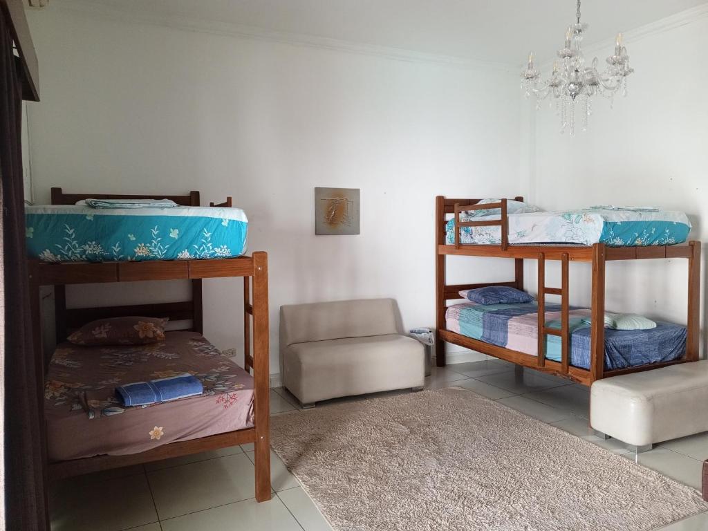 圣克鲁斯Guajira Hostel SCZ的带两张双层床和椅子的房间