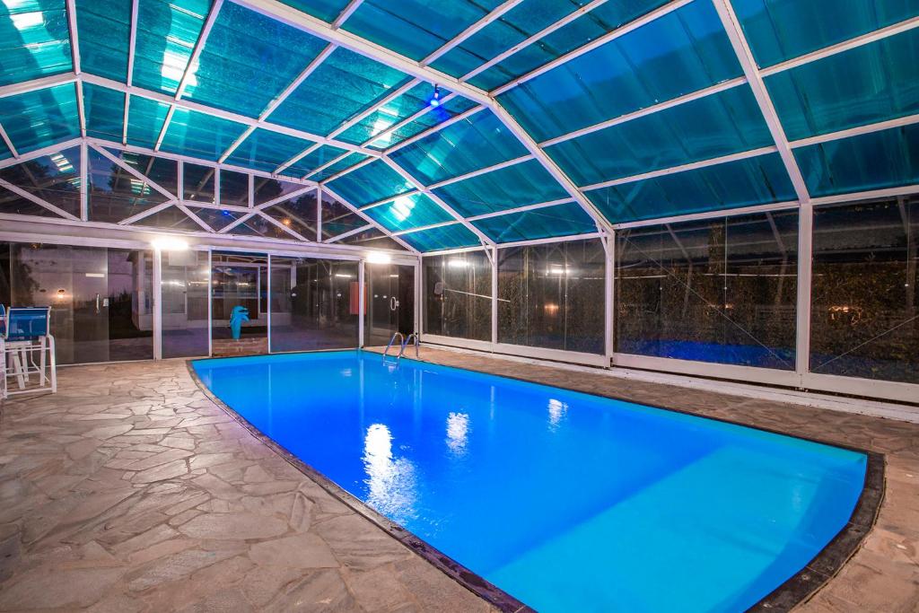 蒙特韦尔迪Pousada das Videiras的一个带玻璃天花板的大型游泳池