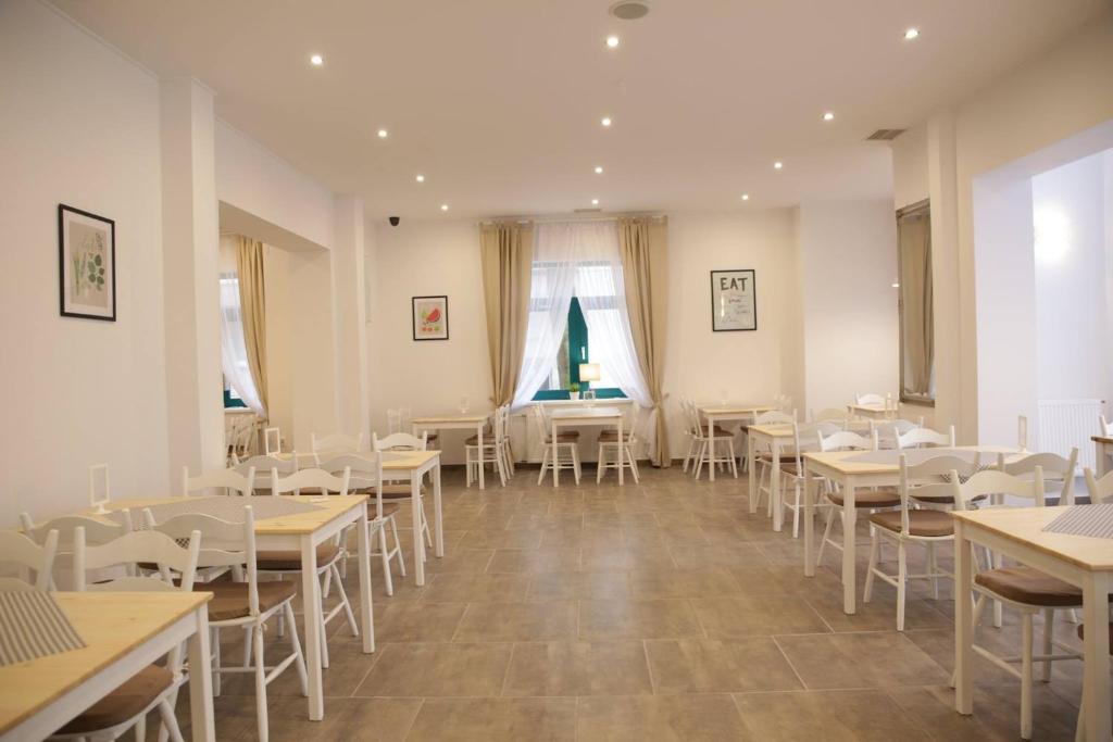 斯维诺乌伊希切Koral Świnoujście的用餐室配有桌子和白色椅子