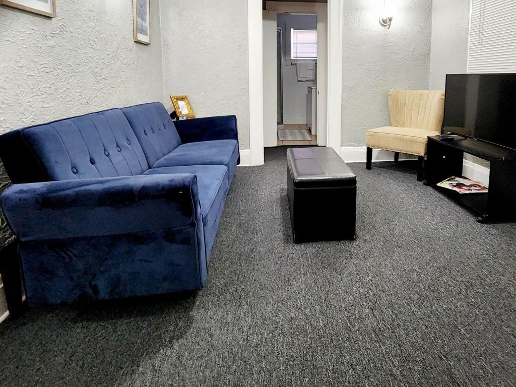莱克兰TWO BEDROOM HOME IN BEAUTIFUL DOWNTOWN LAKELAND的客厅配有蓝色的沙发和椅子