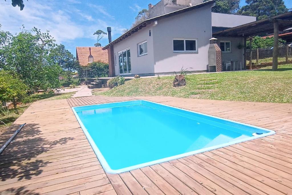 托雷斯Chalé em Torres Recanto Estelar的房子前面的蓝色游泳池