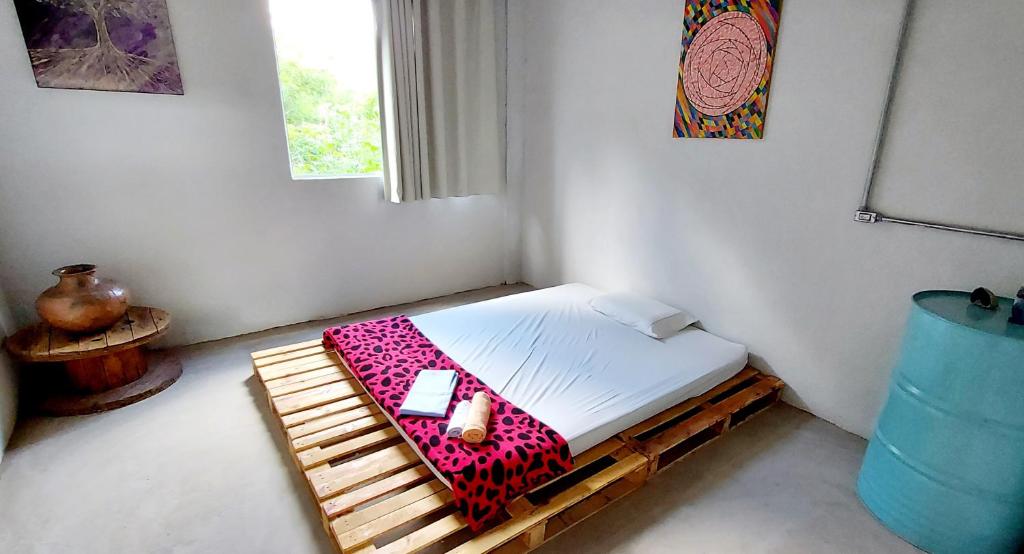 新利马Pousada Vila da Serra - Quarto Cantinho do Sossego的一间小卧室,配有一张带手机的床