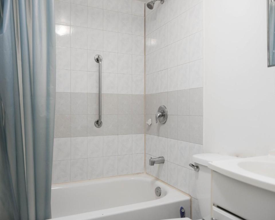 蒙特利尔Cozy studio apartment - 240的白色的浴室设有浴缸和水槽。