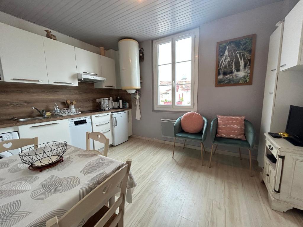乌瑞基尼Appartement Urrugne, 2 pièces, 2 personnes - FR-1-239-508的厨房配有白色橱柜和桌椅