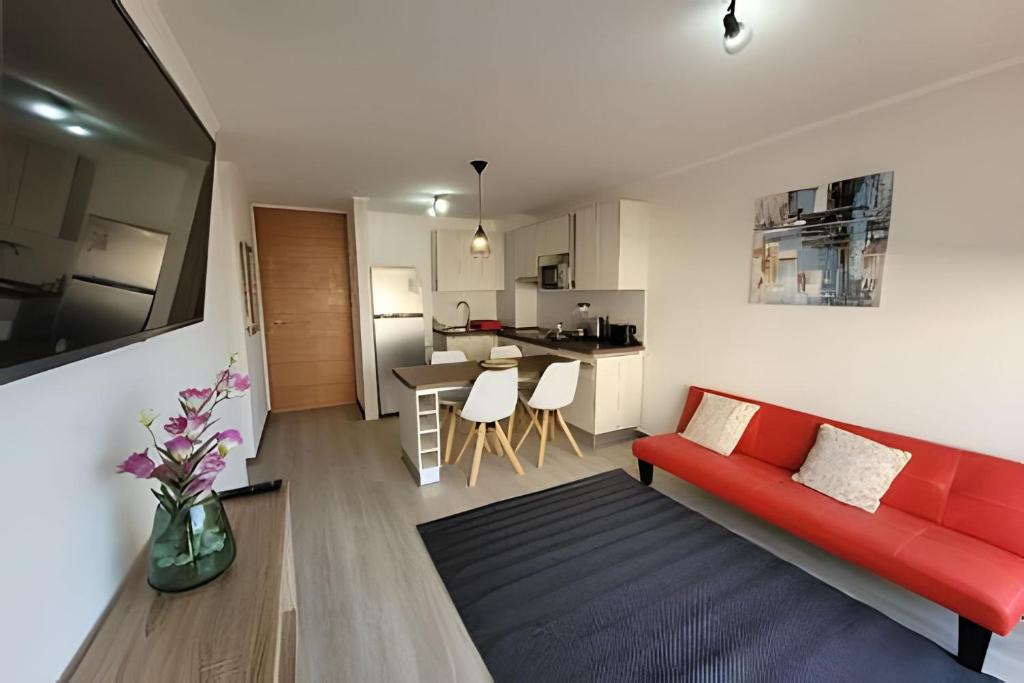 拉塞雷纳Condominio Pacífico 3100的一间带红色沙发的客厅和一间厨房
