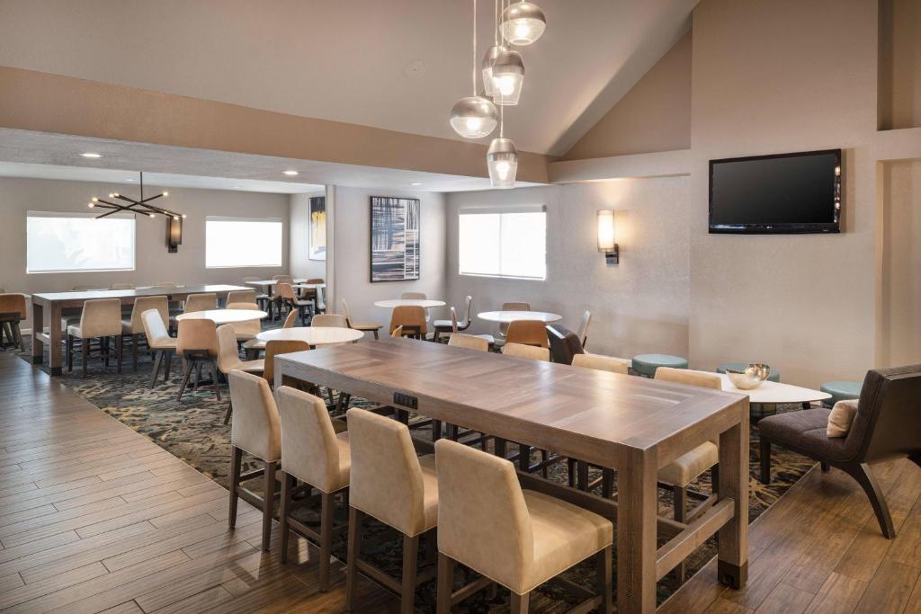 长滩Residence Inn by Marriott Long Beach的用餐室配有桌椅和平面电视。