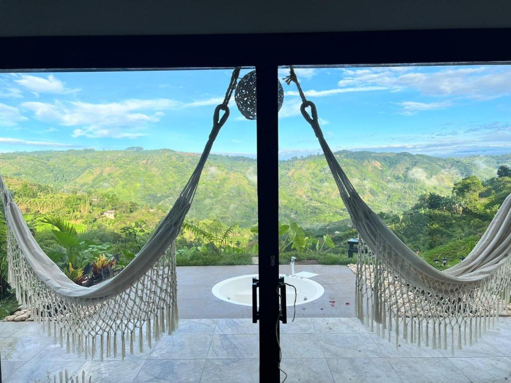 ChinchináNABGUANA的透过带吊床的客房窗户可以欣赏到风景。