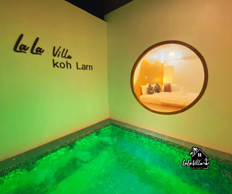 格兰岛Lala Villa Koh Larn的游泳池,位于带圆镜子的房间