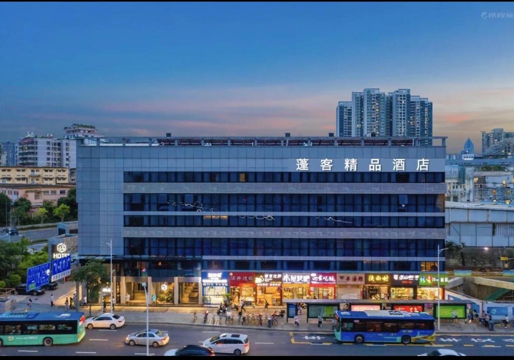 深圳蓬客精品酒店（深圳罗湖宝能中心笋岗地铁站店）的停车场内停放汽车的大型建筑
