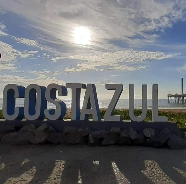 里约达欧特拉斯Casa da Praia em Costazul的海滩上花花旗标志