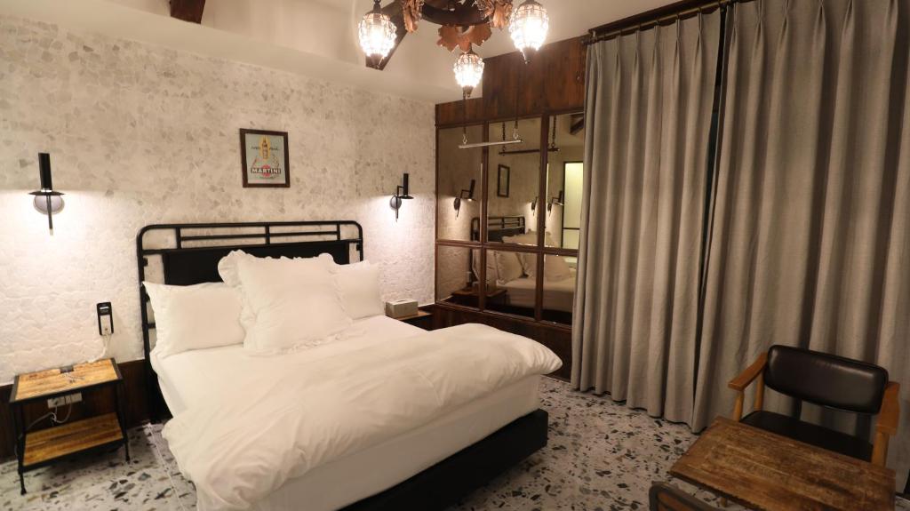 大邱February Hotel SeongSeo的一间卧室配有一张床、一张桌子和一把椅子