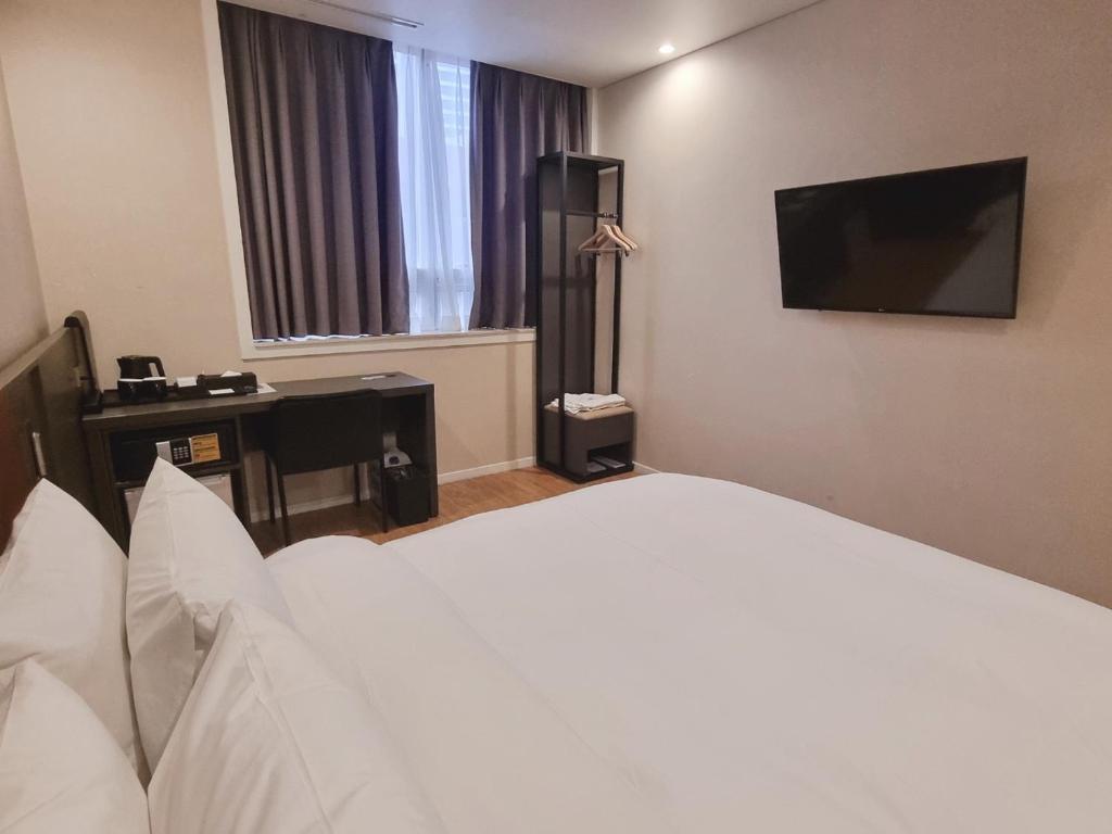 釜山阿尔班市酒店的酒店客房,配有床和电视