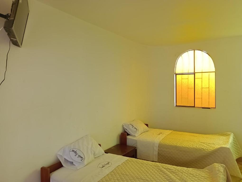 伊察Casa de Campo - Fundo Raquel的客房设有两张床和窗户。