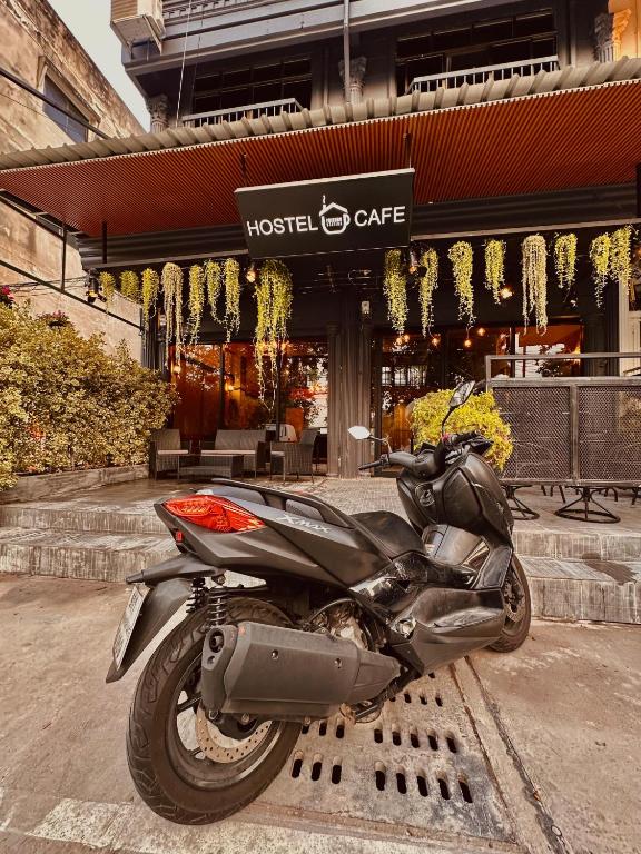 南芭堤雅Hostel Friends Station & Cafe的停在大楼前的摩托车