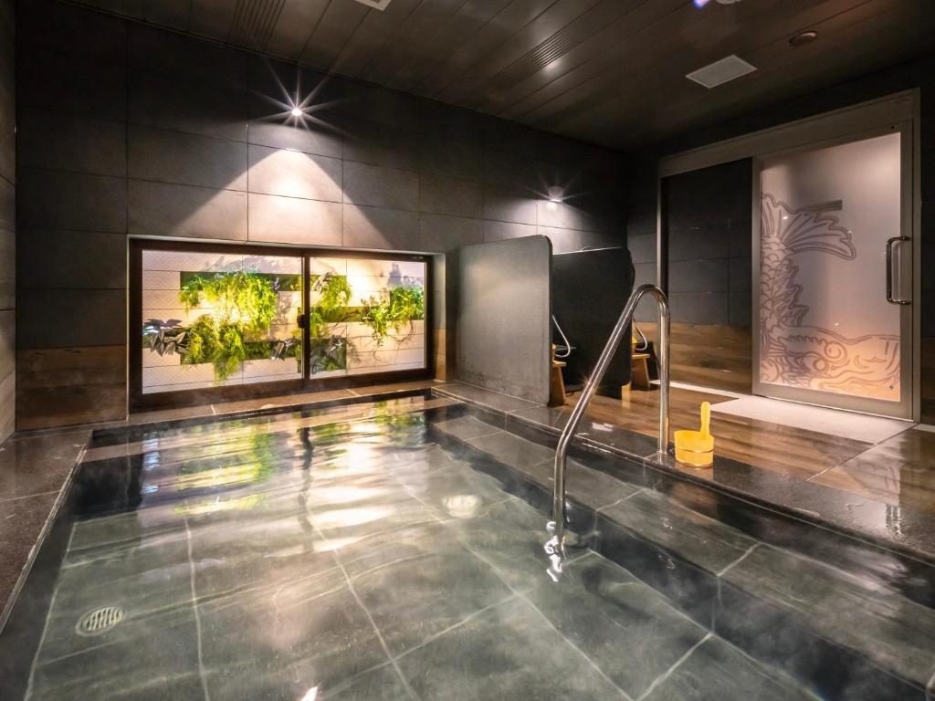 名古屋Super Hotel Nagoya Shinkansenguchi的浴室设有墙上植物游泳池
