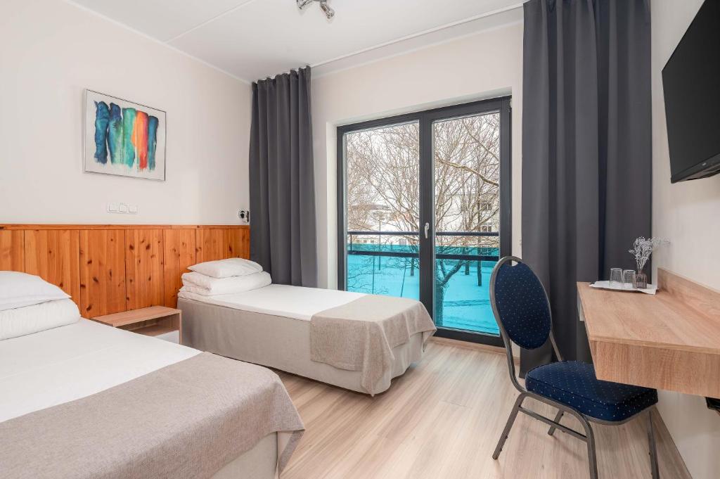派尔努Hotell Tammsaare的酒店客房设有两张床和窗户。