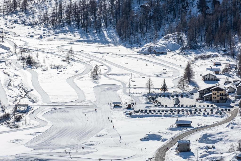 瓦尔萨瓦伦凯阿尔伯戈格兰帕拉迪索酒店的雪覆盖的山,设有滑雪坡和房屋