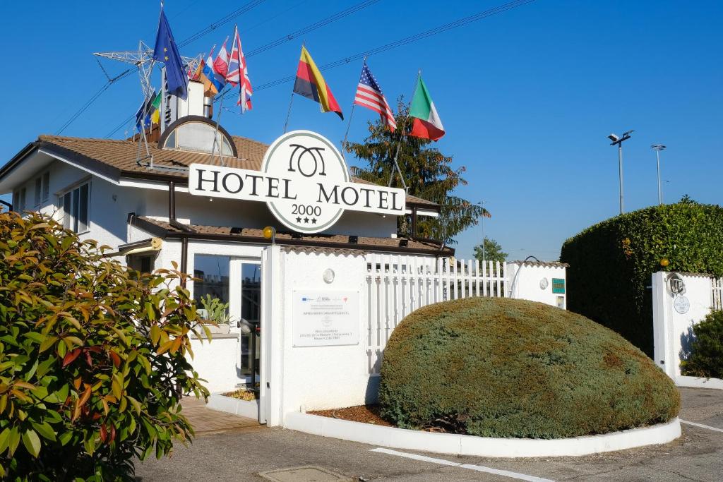 纳维廖河畔特雷扎诺Hotel Motel 2000的汽车旅馆设有标志和一些旗帜