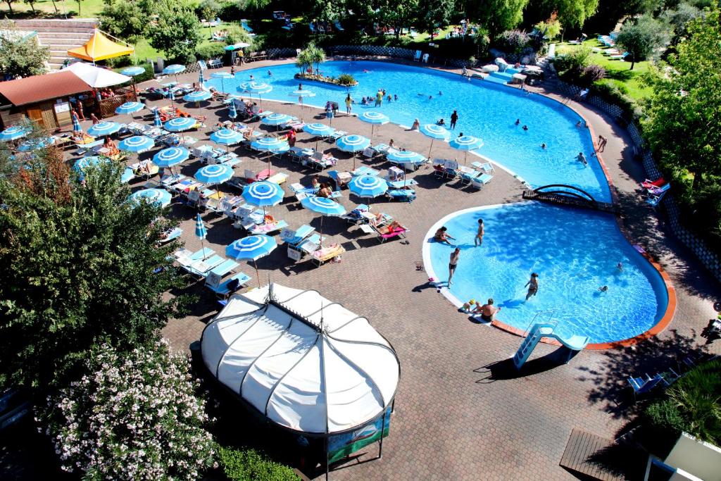 圣马力诺Centro Vacanze San Marino的享有带蓝白遮阳伞的游泳池的顶部景致