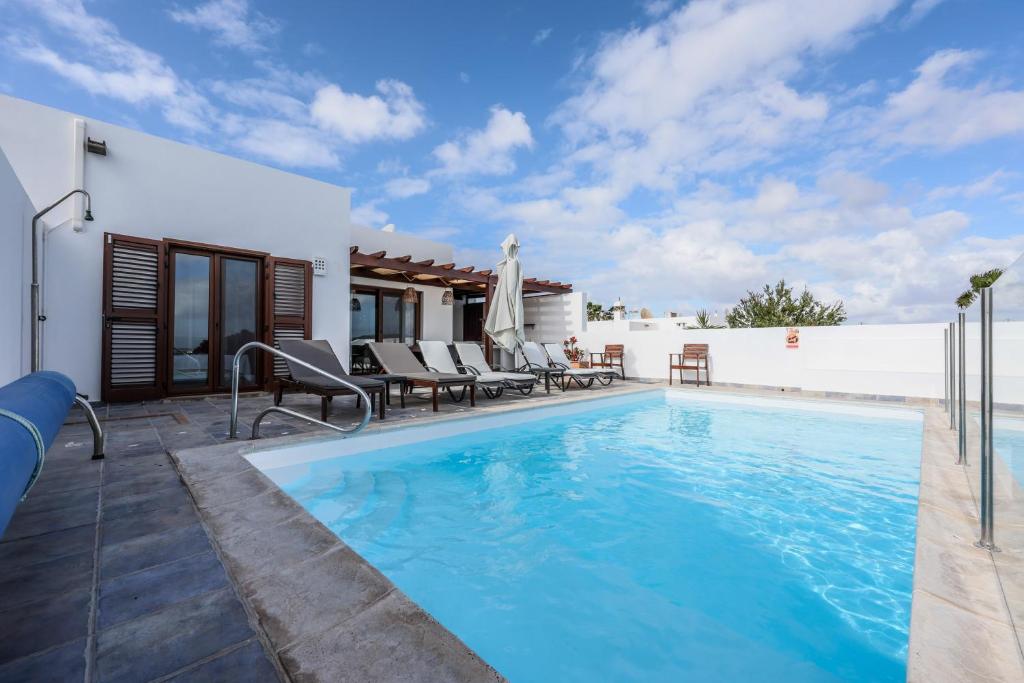 普拉亚布兰卡VILLAS LANZAROTE LOS ALTOS by NEW LANZASUITES Villa SERENA的一座房子后院的游泳池