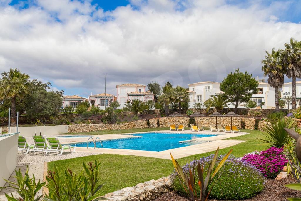 卡武埃鲁Quinta do Rosal, Casa Rosa的庭院里的一个游泳池,有椅子和植物