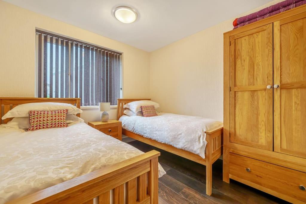 鲍内斯温德米尔Modern Bowness-on-Windermere Flat - Free Parking的一间卧室设有两张床和大窗户