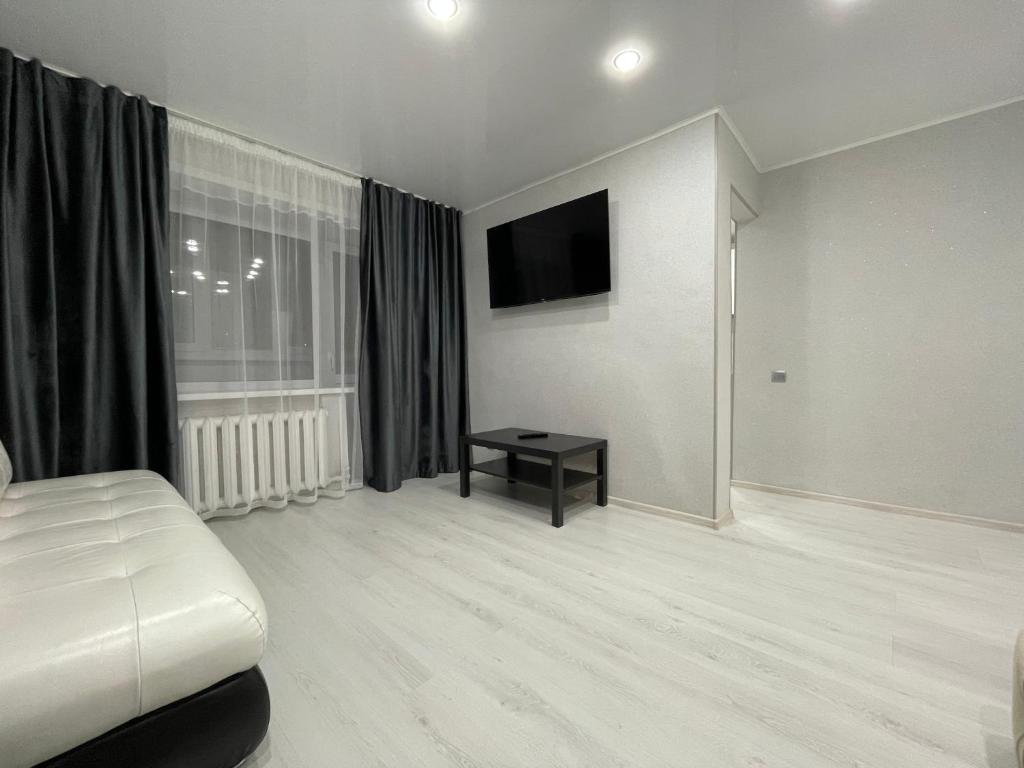 彼得罗巴甫洛夫斯克1-комнатная квартира с дизайнерским ремонтов в районе Вокзала的白色的客房配有床和电视
