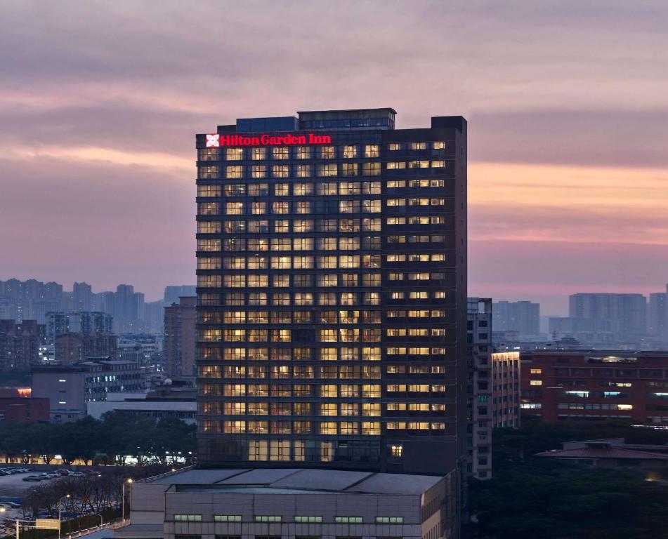 武汉武汉汉口恒信希尔顿花园酒店的一座高大的建筑,上面有红色的标志