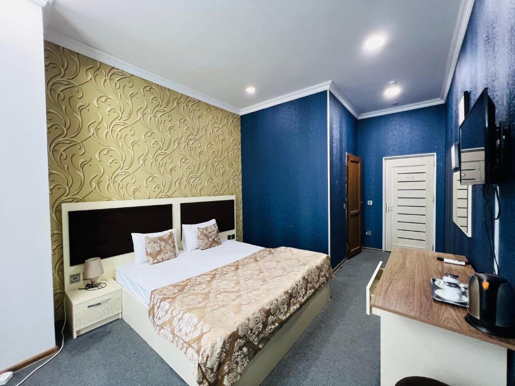 巴库Khegany Mall Hotel的一间卧室设有一张床和蓝色的墙壁