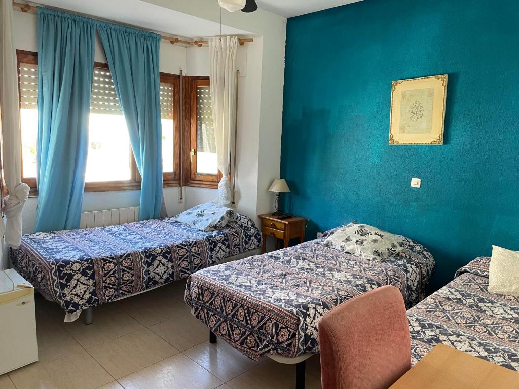 布鲁内特埃尔阿尔巴旅馆的酒店客房,设有两张床和蓝色的墙壁