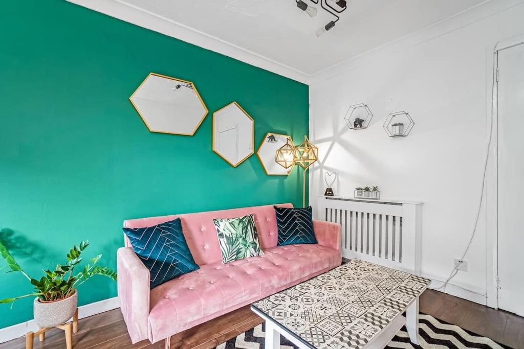 格拉斯哥BrightCentral Apartment With Parking的客厅设有粉红色的沙发和绿色的墙壁