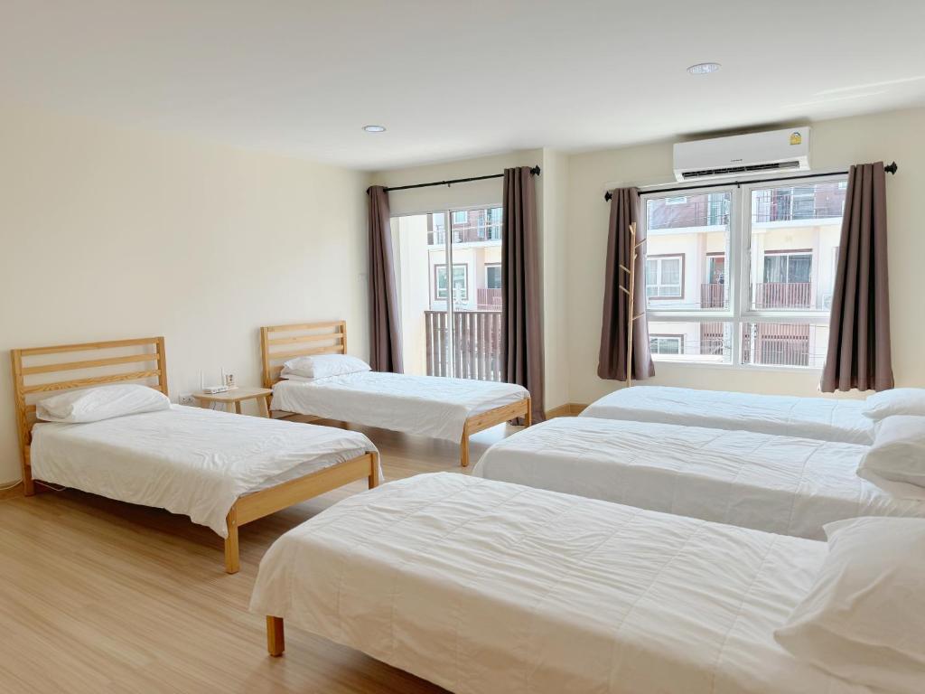 莱卡邦Jira Private cozy room near Suvarnabhumi Airport的酒店客房设有三张床和窗户。