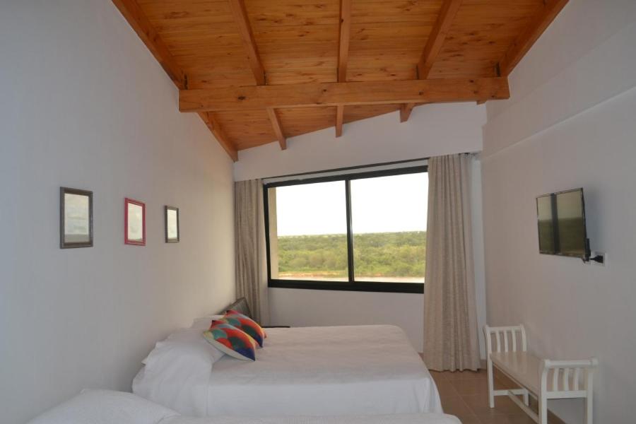 戈亚Costanera Goya Apart & Hotel的一间卧室设有两张床和大窗户