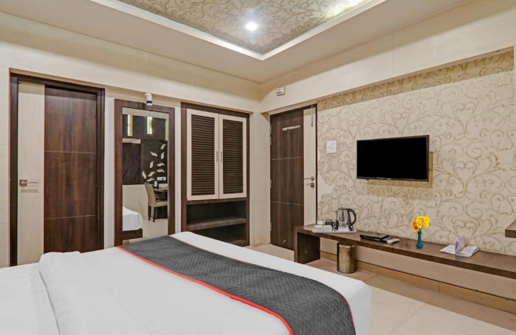 坎普尔Hotel Tirupati Galaxy的一间卧室配有一张床,墙上配有电视