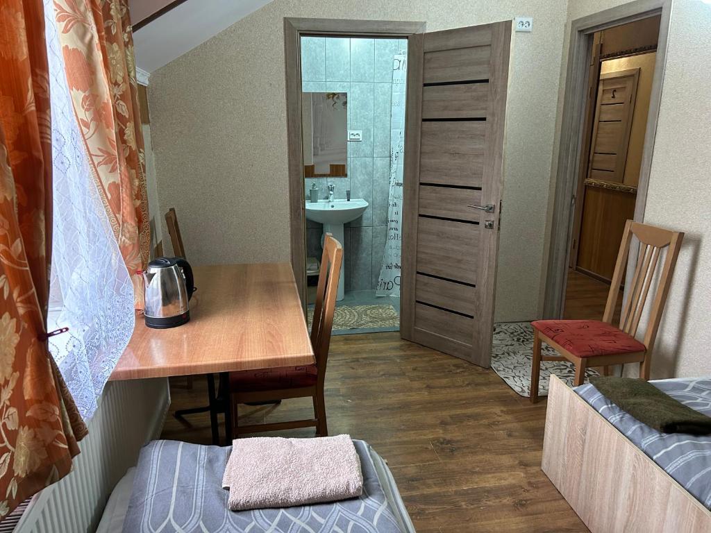 DrogovyzheГотель Максим的小房间设有桌子和浴室