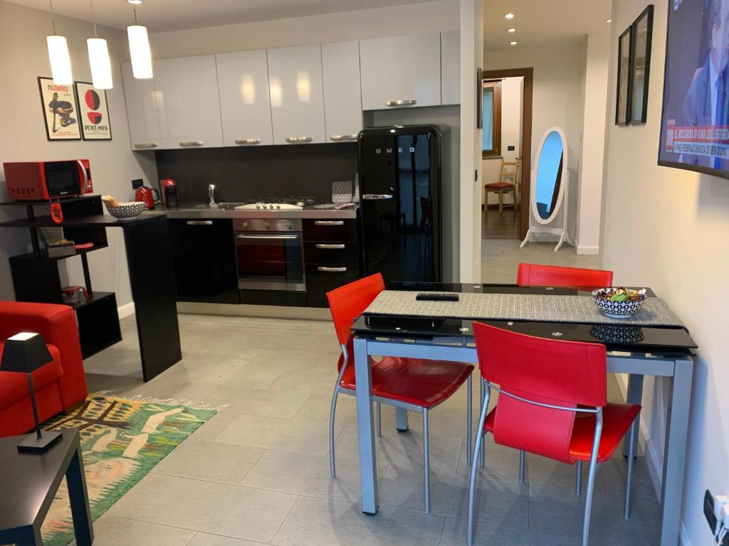 都灵CasaBella Inalpi Arena的一间厨房,内设红色椅子和一个厨房岛