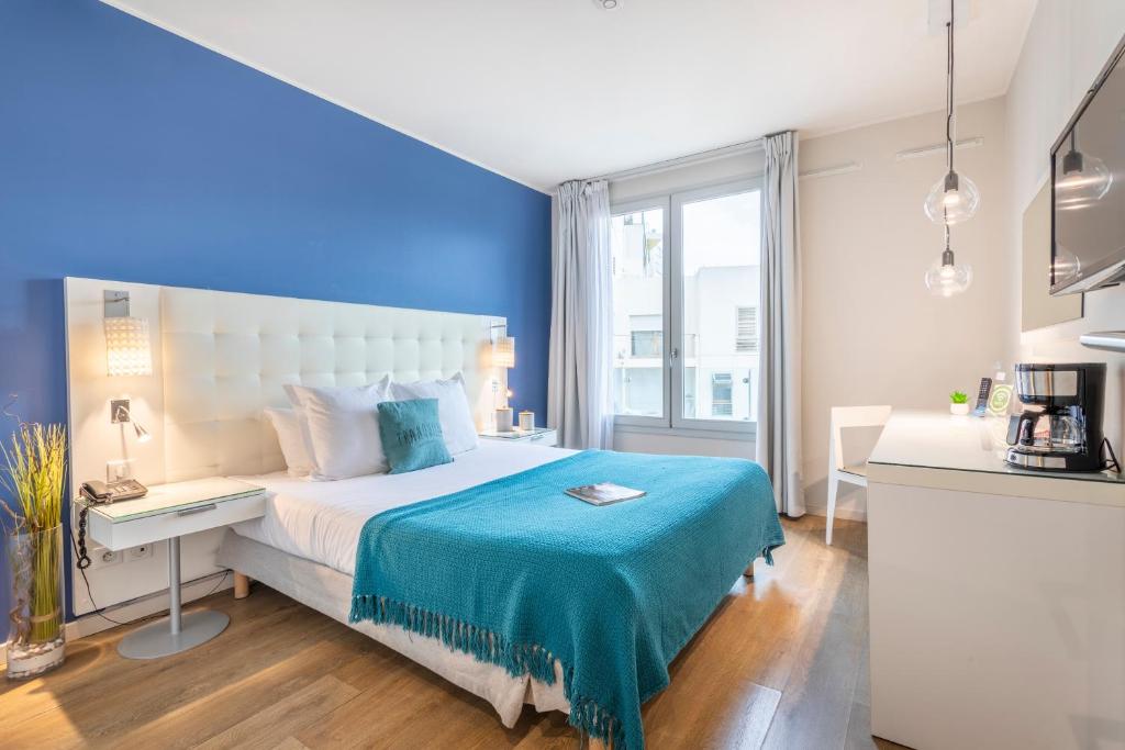 马赛Zenitude Hôtel Résidences Marseille Saint-Charles的一间卧室配有一张蓝色墙壁的床